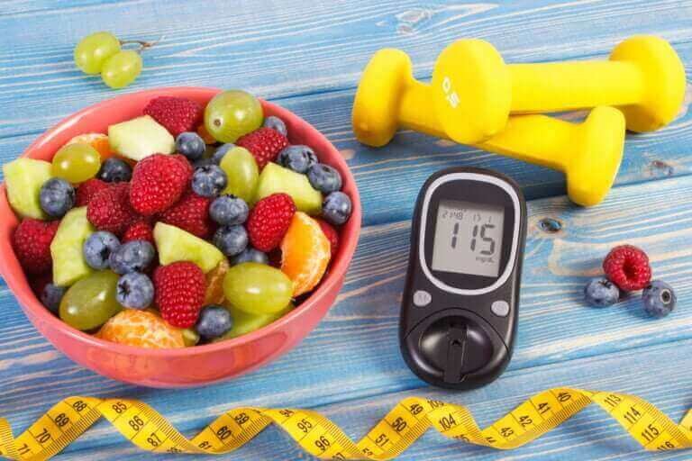 Fresh fruit salad glucometer centimeter and dumbbells diabetes healthy lifestyle and nutrition concept Nutricionista Bárbara SantAna